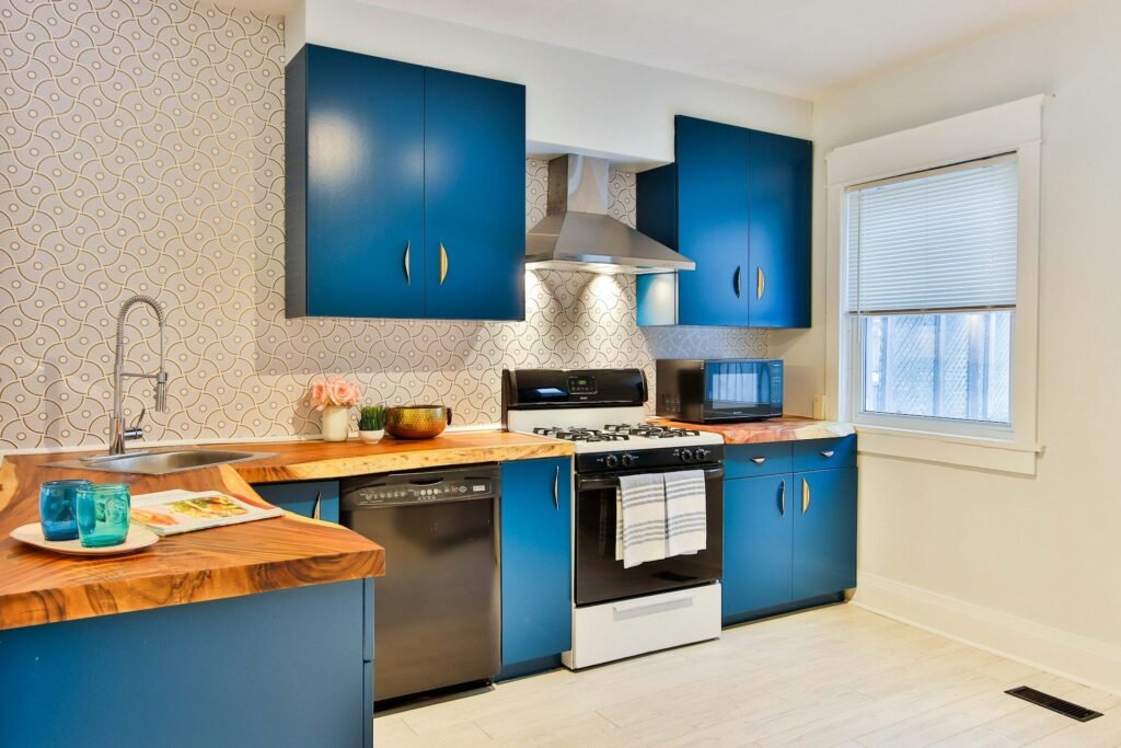 Cocina con muebles azul intenso y encimera de madera