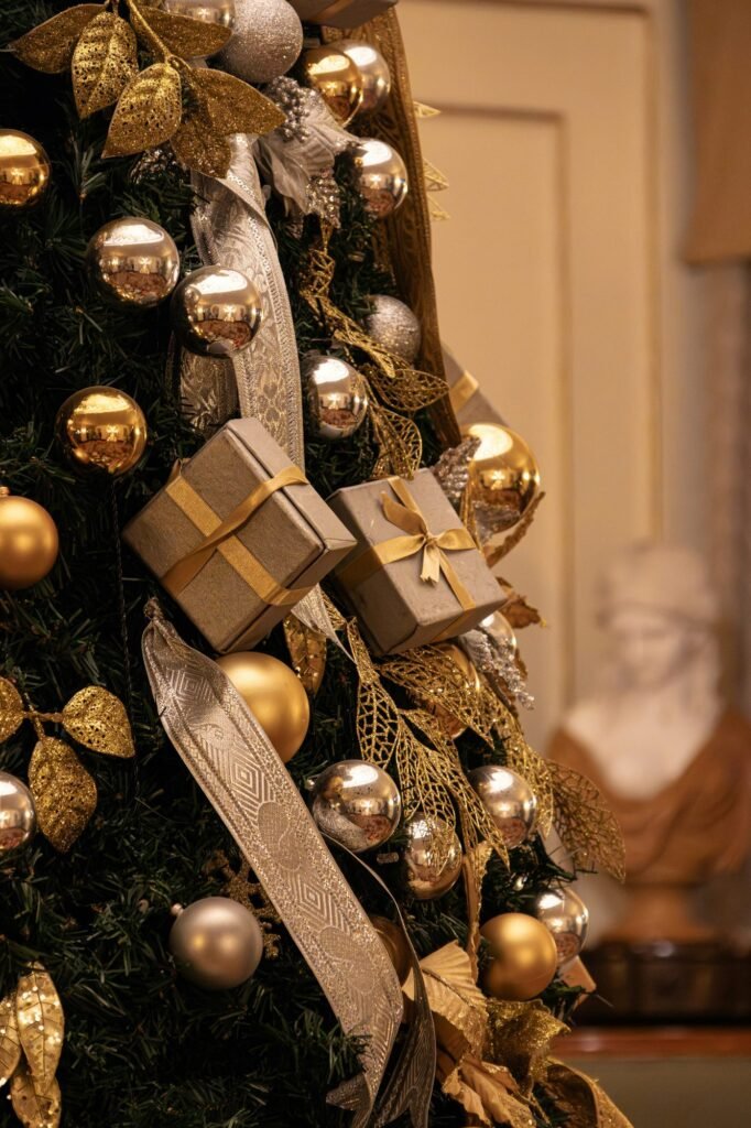 Detalle de un árbol con bolas doradas, lazos y pequeños regalos envueltos en papel dorado