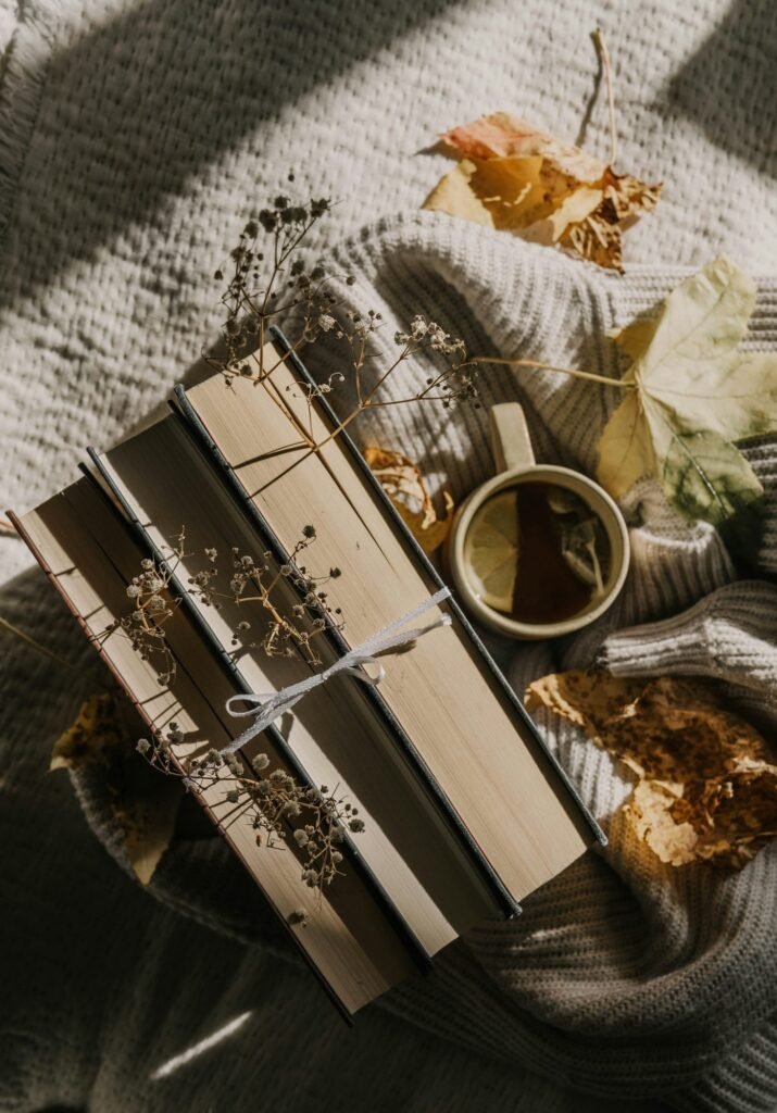 Libros atados con cordel y una taza de té sobre una manta
