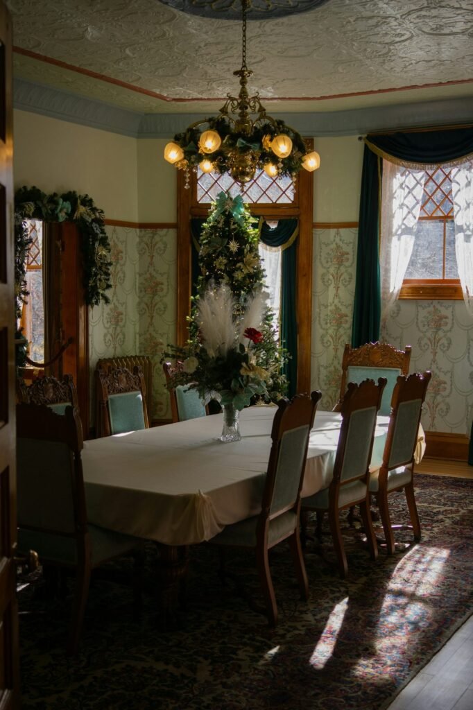 Comedor clásico con lámpara de araña decorada con ramas y mesa con mantel blanco