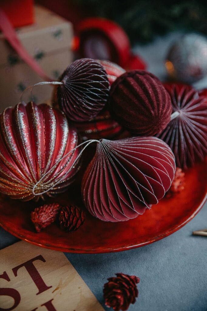 Adornos de papel en forma de nido de abeja en tonos burdeos sobre un plato rojo