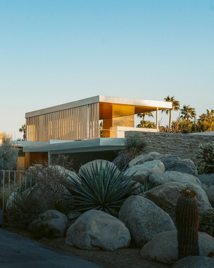 Casa modernista de líneas horizontales entre rocas y plantas del desierto