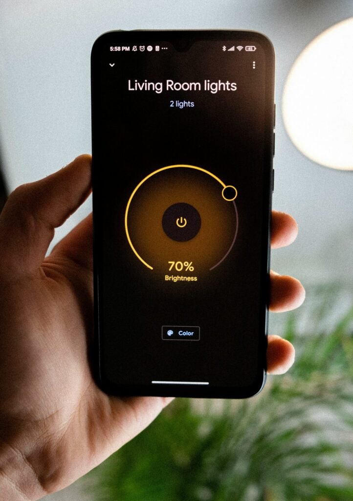Mano sosteniendo un móvil con una aplicación para regular la luz del salón